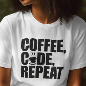 Könnte beinhalten: Weißes T-Shirt mit schwarzem Text, der "Coffee, Code, Repeat" lautet, und einem kleinen Kaffeetassen-Symbol.