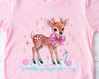 May include: Pink toddler t-shirt with a cute cartoon deer wearing a pink bow. The deer is surrounded by gold stars, candy canes, and presents. The shirt is perfect for a Christmas or winter holiday.