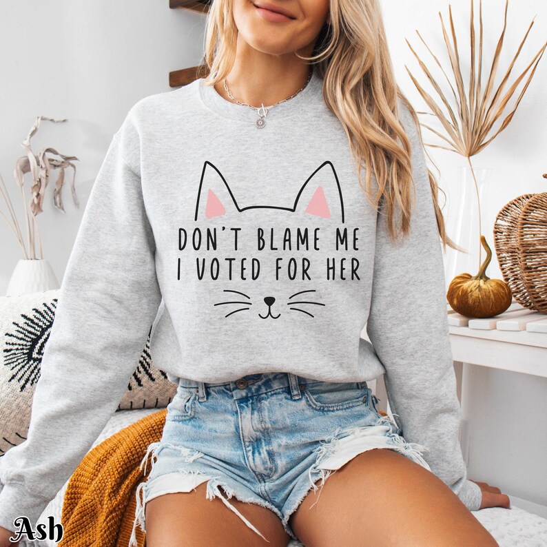 May include: Gray sweatshirt with a cat graphic and the text "Don't blame me I voted for her".