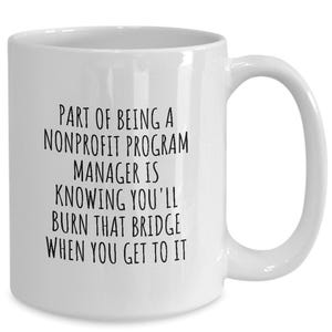 May include: White ceramic coffee mug with black text that reads "Part of being a nonprofit program manager is knowing you'll burn that bridge when you get to it."