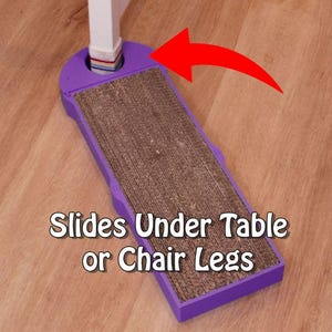 May include: A purple cat scratcher with a cardboard scratching surface. The scratcher is designed to slide under table or chair legs. Text on the image reads "Slides Under Table or Chair Legs."