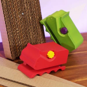 May include: Two cardboard box sealing tools. One is red with a yellow knob and the other is green with a purple knob.