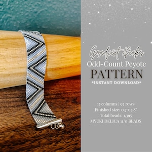 May include: A beaded bracelet with a gradient pattern in shades of blue, black, and silver. The bracelet is made with 1,395 Miyuki Delica 11/0 beads and measures 0.7 inches wide by 5.8 inches long. The pattern is called "Gradient Peaks" and is an odd-count peyote stitch.
