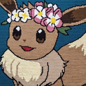 May include: A rectangular crochet blanket featuring a brown Eevee character with a cream-colored chest ruff, large dark eyes, and a flower crown made of white and pink blossoms with yellow centers, set against a solid dark blue background.