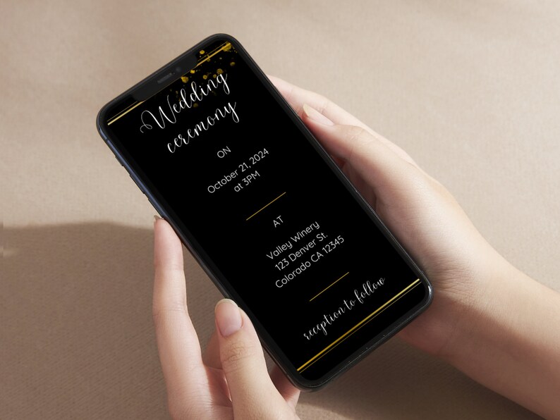 May include: A black smartphone screen displays a wedding ceremony invitation with gold accents. The invitation includes the date, time, location, and the text "reception to follow".