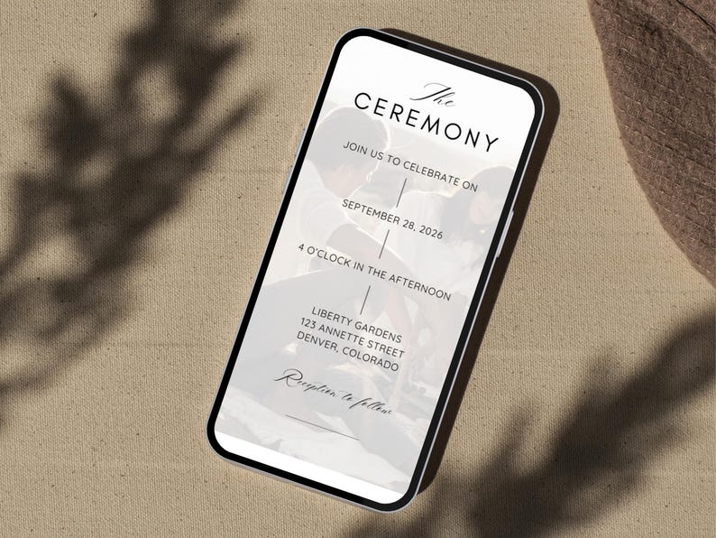May include: A smartphone screen shows a wedding invitation with the words "The Ceremony." The invitation details the date, time, and location: September 28, 2026, at 4 o'clock in the afternoon, at Liberty Gardens, 123 Annette Street, Denver, Colorado.