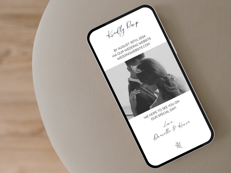 May include: A black and white photograph of a couple on their wedding day. The text on the phone screen reads "Kindly RSVP by August 30th, 2024 via our wedding website weddingwebsite.com. We hope to see you on our special day! Love, Danielle & Keren."