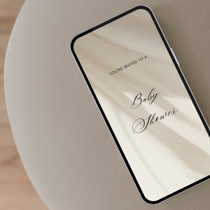May include: A smartphone displaying a digital invitation to a baby shower. The invitation reads "You're invited to a Baby Shower".