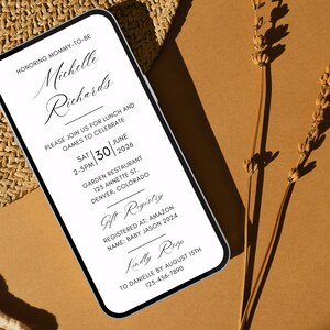 May include: A white and black mobile phone screen displaying a baby shower invitation for Michelle Richards. The invitation includes the date, time, location, and gift registry information. The text reads "Honoring Mommy-to-be Michelle Richards. Please join us for lunch and games to celebrate Sat | 30 | June 2-5pm | 2026 Garden Restaurant 123 Annette St. Denver, Colorado Gift Registry Registered at: Amazon Name: Baby Jason 2024 Kindly RSVP To Danielle by August 15th 123-456-7890"