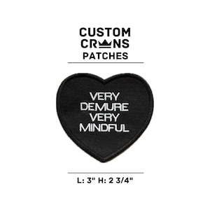 May include: Black heart-shaped patch with white embroidered text that reads "VERY DEMURE VERY MINDFUL". The patch measures 3 inches wide and 2 3/4 inches tall.
