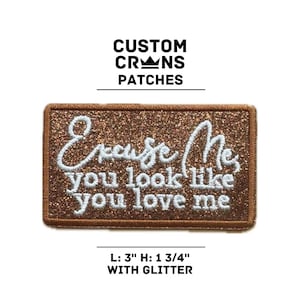 May include: A brown glitter iron-on patch with white embroidery that reads "Excuse Me, you look like you love me". The patch is 3 inches wide and 1 3/4 inches tall.