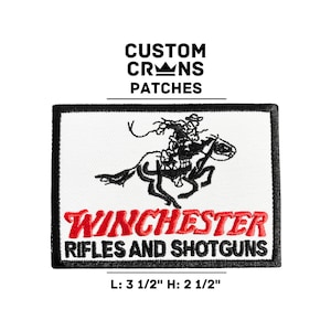 May include: White embroidered patch with a black and white illustration of a cowboy riding a horse. The text "WINCHESTER RIFLES AND SHOTGUNS" is in red lettering. The patch is 3 1/2 inches wide and 2 1/2 inches tall.