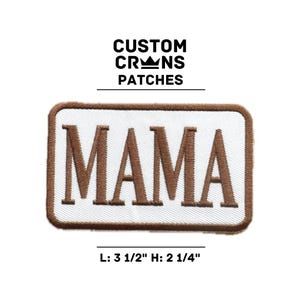 May include: Brown embroidered patch with white background and the word "MAMA" in brown lettering. The patch is 3 1/2 inches wide and 2 1/4 inches tall.