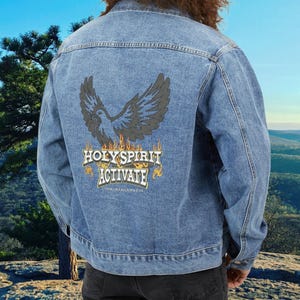 May include: A blue denim jacket with a graphic of a dove with flames and the text "HOLY SPIRIT ACTIVATE" on the back.
