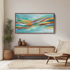 May include: Abstract art piece with a brown frame. The artwork features a flowing design of colorful brushstrokes in shades of blue, orange, yellow, green, and red. The painting is displayed above a wooden cabinet with decorative vases.