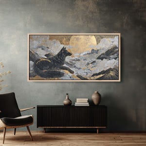 May include: A framed artwork depicts a black wolf in a mountainous landscape with a golden moon. The painting features shades of gray, gold, and black, creating a dramatic and serene scene. The artwork is displayed in a room with a dark accent wall.