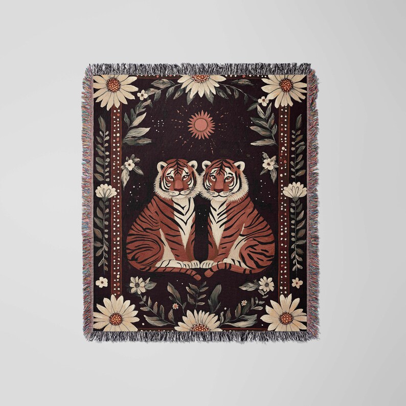 K&ouml;nnte beinhalten: Eine gewebte Wandteppich mit zwei Tigern, die nebeneinander auf einem dunklen Hintergrund sitzen. Die Tiger sind von einem floralen Rand mit wei&szlig;en G&auml;nsebl&uuml;mchen und gr&uuml;nen Bl&auml;ttern umgeben. Eine kleine Sonne befindet sich oben in der Mitte des Wandteppichs.