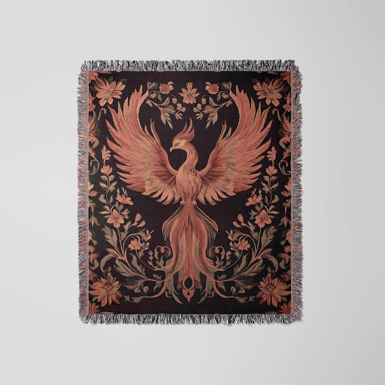 May include: A woven throw blanket with a dark background featuring a stylized orange phoenix rising from a bed of floral vines.