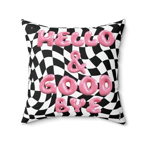 May include: Pink "Hello & Goodbye" text on a black and white checkered pillow with a wavy pattern.