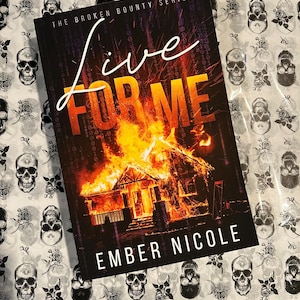 May include: A book cover with the title "Live For Me" in a fiery orange font. The background image is a house engulfed in flames. The author's name, "Ember Nicole", is printed in white at the bottom of the cover. The book cover is part of "The Broken Bounty Series".