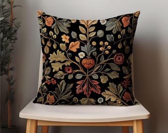 May include: A black throw pillow with a floral pattern featuring leaves, flowers, and berries in shades of orange, red, green, and white.