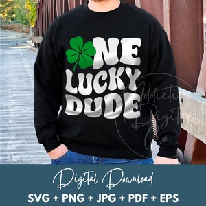 May include: Black sweatshirt with the text "ONE LUCKY DUDE" in white, with a green shamrock. The words are in a retro font. Below the sweatshirt is the text "Digital Download" and file types.