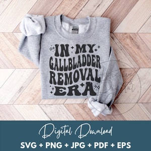 May include: A heather gray sweatshirt with the text "IN MY GALLBLADDER REMOVAL ERA" in black, retro-style lettering. The design includes star accents. The image also includes the words "Digital Download" and file type information.