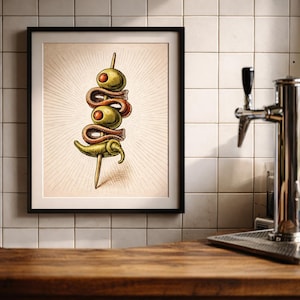 Puede incluir: Una impresión enmarcada que presenta una ilustración de estilo vintage de un pintxo, un pincho de tapas español. El pincho incluye aceitunas verdes, anchoas y un pimiento. La obra de arte está ambientada sobre un fondo crema con líneas radiales.