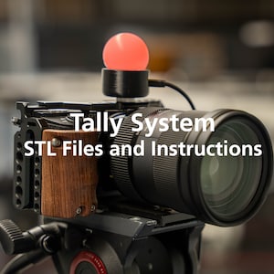 May include: A black camera with a red tally light on top. The camera is mounted on a tripod and has a lens attached. The text "Tally System STL Files and Instructions" is displayed on the camera.