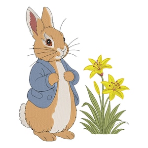 May include: An embroidered illustration of a brown rabbit with long ears, wearing a blue jacket, standing next to a cluster of two yellow lily flowers with green stems and leaves. The rabbit has a white chest and dark brown eyes and whiskers.