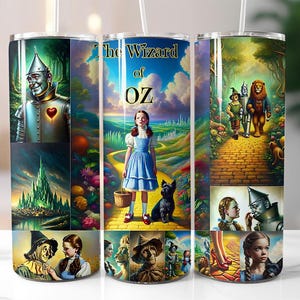 May include: A stainless steel tumbler with a colorful design featuring characters from the Wizard of Oz. The design includes Dorothy, the Tin Man, the Cowardly Lion, and the Wicked Witch of the West. The tumbler has a straw and a lid.