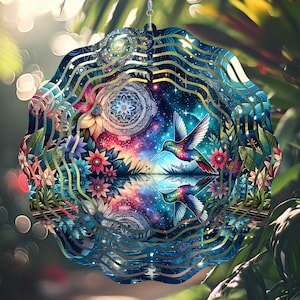 Puede incluir: Un molinillo de viento de metal colorido con un colibrí y un diseño floral. El colibrí está volando a través de una galaxia con estrellas y un mandala. El molinillo de viento tiene múltiples capas de metal que crean un efecto de remolino.