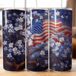 Puede incluir: Tres vasos de acero inoxidable con un diseño patriótico. Los vasos presentan un fondo azul con flores blancas y una bandera estadounidense roja, blanca y azul ondeando al viento.