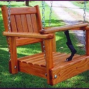 May include: Wooden swing seat with a slatted back and seat, and a small armrest on each side. The swing is hanging from chains.