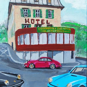 以下が含まれることがあります： 赤い日よけと上に「HOTEL」の文字があるホテルのアクリル画。 ピンク、黒、青の3台のクラシックカーがホテルの前に駐車されています。 このアートワークはヴィンテージな美学を持っています。