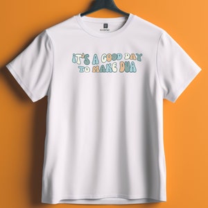 May include: White t-shirt with the text "It's a good day to make dua" in colourful, bubbly letters.