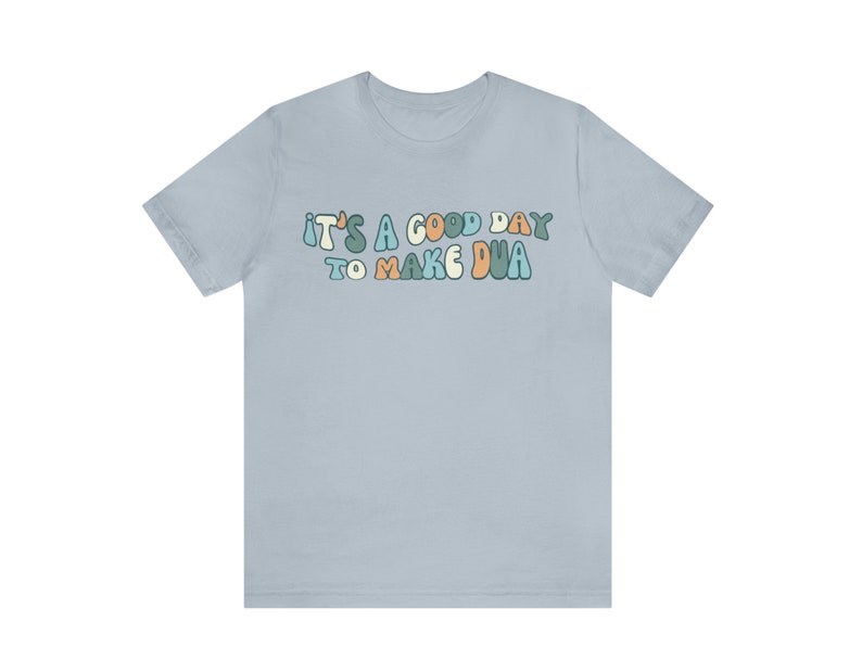 May include: Light blue t-shirt with the text "It's a good day to make dua" in a colourful, retro font.