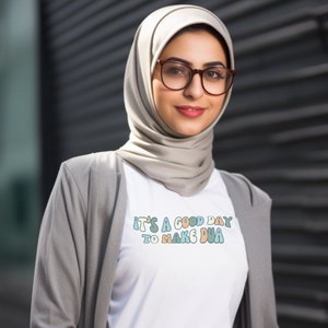 May include: A white t-shirt with the text "It's a good day to make dua" in colourful, stylized lettering.