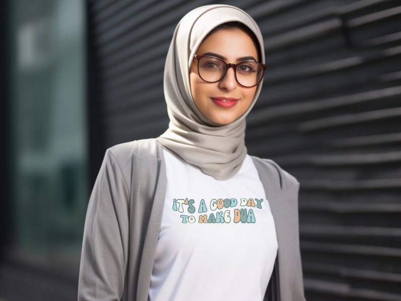 May include: A white t-shirt with the text "It's a good day to make dua" in colourful, stylized lettering.