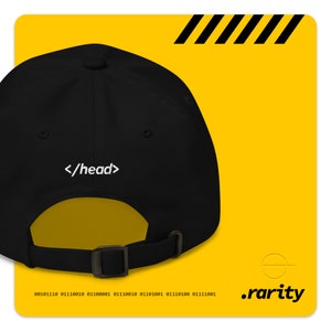 K&ouml;nnte beinhalten: Schwarze Baseballkappe mit wei&szlig;er Stickerei, die auf der R&uuml;ckseite "</head>" lautet. Die Kappe hat einen schwarzen verstellbaren Riemen mit einer Metallschnalle.