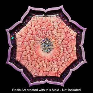 Op de afbeelding: Een decoratief harskunstwerk in bloemvorm, met een roze en perzik centrum met een textuurpatroon. De randen zijn omlijnd met donkerpaarse glitter en omlijst door een lichtpaarse rand. Het midden heeft zilveren glitter. De tekst onderaan luidt: Resin Art created with this Mold - Not included.