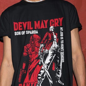 Könnte beinhalten: Schwarzes T-Shirt mit einer rot-weißen Grafik aus dem Videospiel "Devil May Cry". Das Design enthält den Text "Devil May Cry Son of Sparda" und die Figur "Dante" mit dem Satz "My job is to hunt demons."