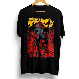 May include: Black t-shirt with a red and yellow graphic print of a demon character with the Japanese text "デビルマン" on the front.