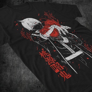 Könnte beinhalten: Schwarzes T-Shirt mit einer Grafik eines Anime-Charakters mit weißen Haaren, einer schwarzen Maske und einem roten herzförmigen Design. Roter japanischer Text ist vertikal auf das Shirt gedruckt.