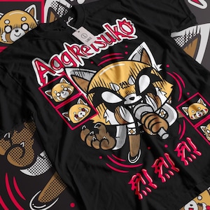 以下が含まれることがあります： パンクロックスタイルの赤いパンダのキャラクターが描かれた黒いTシャツ。キャラクターはマイクに向かって歌っており、獰猛な表情をしています。「アグレッシブ」という文字が太字の赤いフォントで書かれています。Tシャツには、赤いパンダの小さな画像がいくつか描かれています。