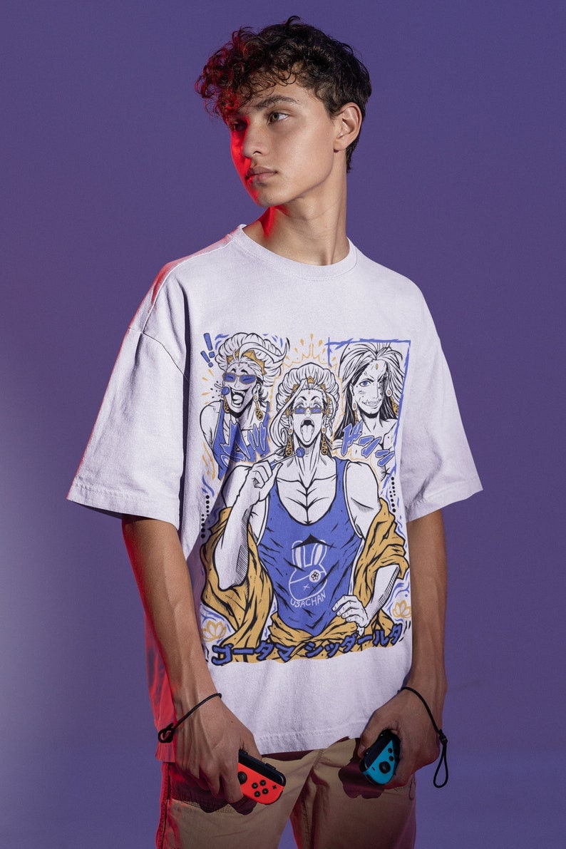 May include: A white t-shirt with a graphic print of a cartoon character with a blue tank top and yellow robe. The character is surrounded by other cartoon characters. The text "コーチマン" is printed on the shirt.