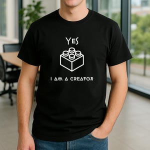 Puede incluir: Camiseta negra con un gráfico blanco de un ladrillo Lego y el texto "YES I AM A CREATOR".