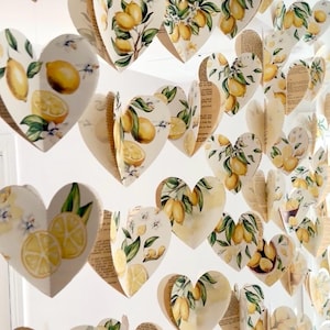 May include: Decorative paper hearts with a lemon theme. Each heart features a watercolor design of lemons, leaves, and flowers. The hearts are layered and create a 3D effect, perfect for party decorations or home decor.
