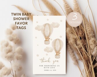 May include: Twin baby shower favor tags with a design of two brown teddy bears in hot air balloons with clouds and stars. The text reads "thank you for showering us with love Emma & Jon".