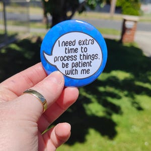 May include: A blue button with a white speech bubble that says "I need extra time to process things, be patient with me".
